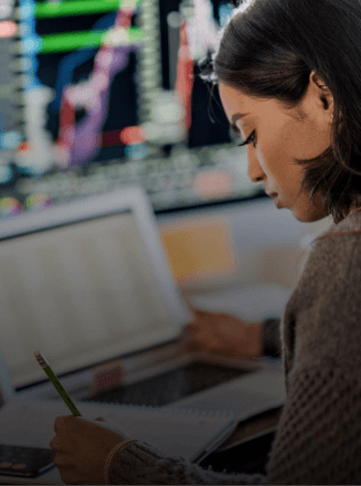 Financial specialist working with a pencil with a laptop open next to her