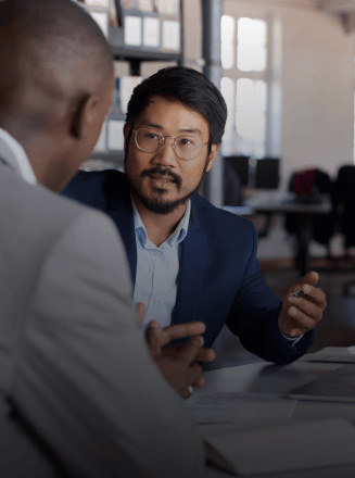 Asian and African American lawyers talking at a table