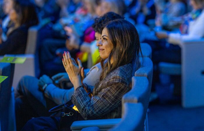 Attendee applauding during a live business event session.
